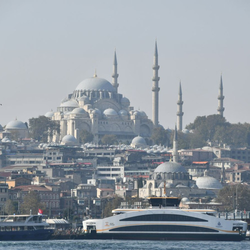 a large boat in the water near a city